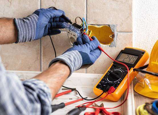 Electrician inspecting outlet wiring connections during a repair